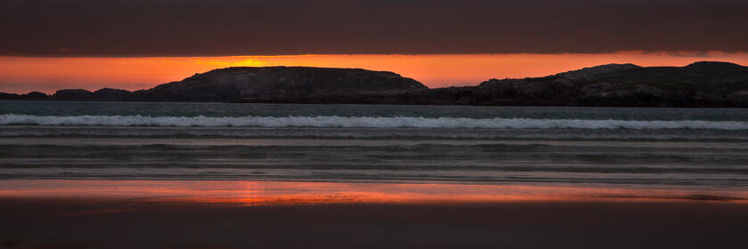 An orange-red sunset falls over Uig Bay on the Isle of Lewis and Harris