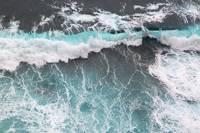 Looking vertically down from a cliff onto a wave breaking on the shore, in São Jorge on Madeira.